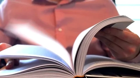Young man flips pages in his book Stock Footage 84949633