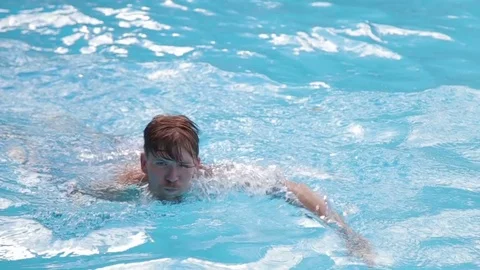 A young man floating in the pool Stock Footage 70774288