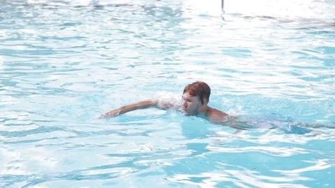 A young man floating in the pool Stock Footage 70774542