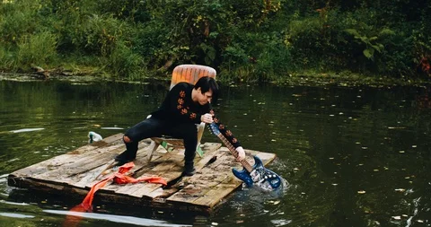 Young man floating on a raft. He's rowing an electric guitar. Cool footage Stock Footage 114520439