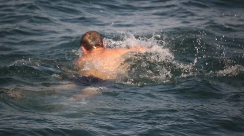 Young man floating on the sea crawl style Stock Footage 59998406