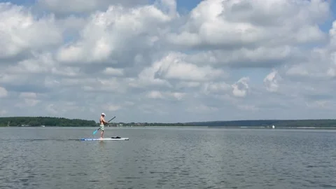 Young man floating on a sup board 스톡 동영상 132192006