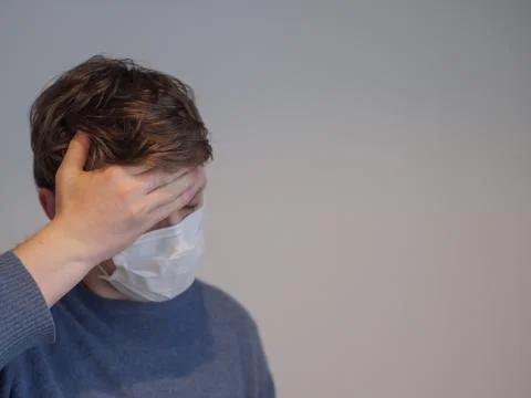 A young man with the flu checking his temperature Stock Photos