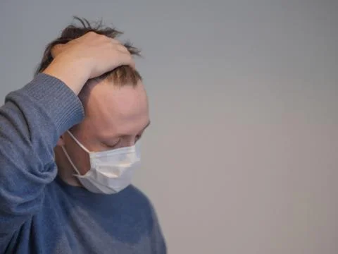 A young man with the flu checking his temperature Stock Photos