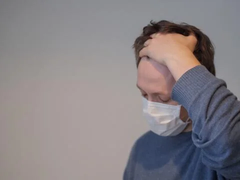 A young man with the flu checking his temperature Foto stock