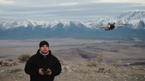 A young man flying a drone at sunset in the mountains. Stock-Footage 312192429