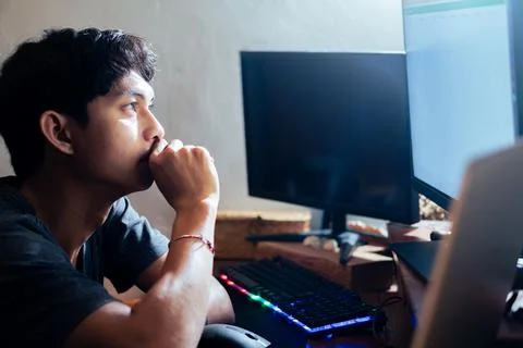 Young man focused on computer screen at desk Stock Photos