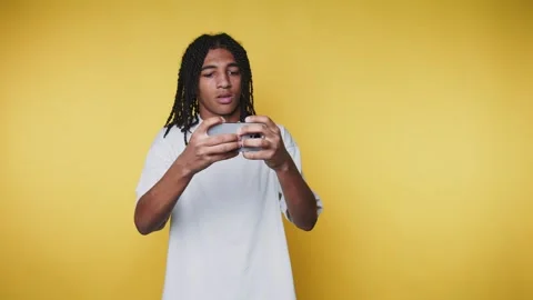 Young man focused on his smartphone displays a curious expression, showcasi.. Stock Footage 313280192