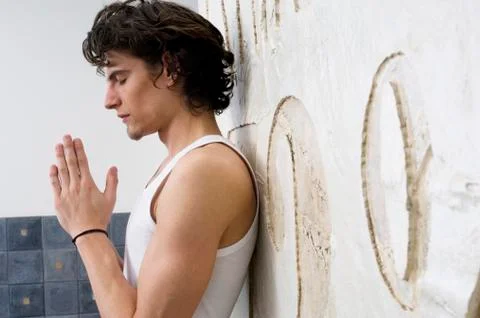 Young man with folded hands, closed eyes Stock Photos