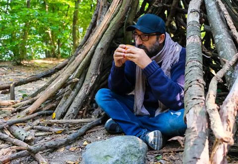 Young man in the forest drinking coffee under a shelter Stock Photos