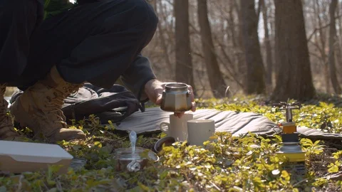 Young man in the forest making coffee Stock Footage 129074899