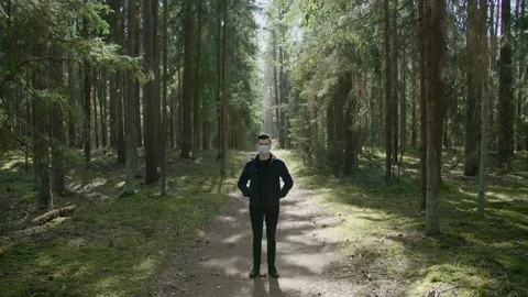 Young man in a forest in a protective mask. COVID19 Stock Footage 129749669