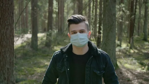 Young man in a forest in a protective mask. COVID19 Stock Footage 129750023