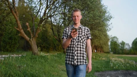 Young man in the forest watching his smartphone Stock Footage 130129948