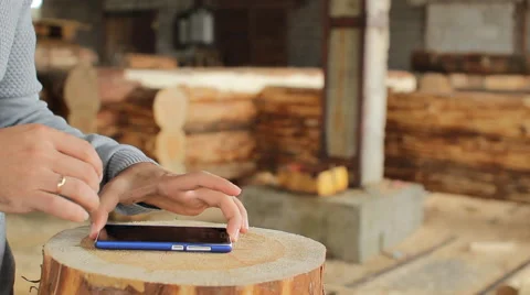 Young man forestry engineer touch phone in front of wood Stock Footage 65318228