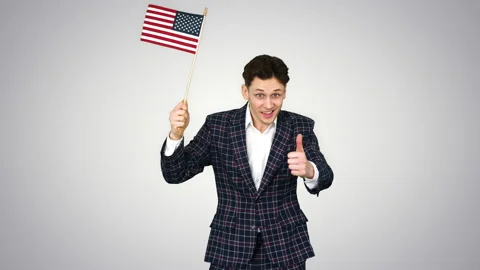 Young man in formal suit dancing in a funny way with American flag on gradient Stock Footage 131010605