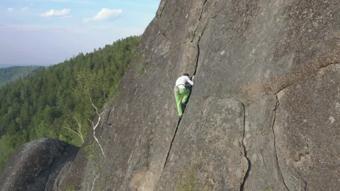 A young man free climbing a vertical wall. Video stock 130896902