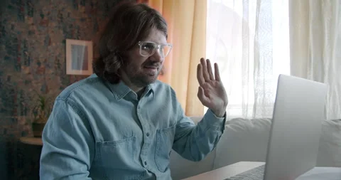 Young man freelancer call online, online conversation on his laptop. long hair Stock Footage 245808523
