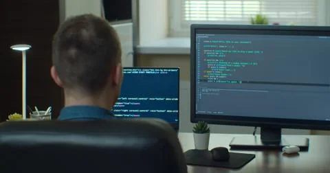Young man freelancer coding html and programming on two screen Monitors 스톡 사진