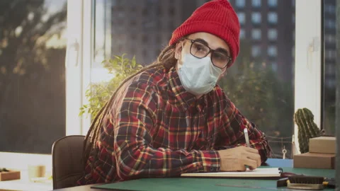 Young man freelancer designer working in office. People wear protective face Stock Footage 140204368