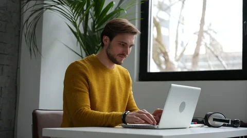 Young man freelancer entrepreneur using laptop online working from home Video stock 229776333