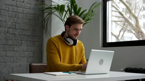 Young man freelancer entrepreneur using laptop online working from home Video stock 229777196