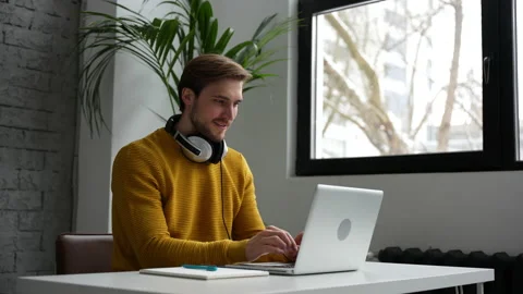 Young man freelancer entrepreneur using laptop online working from home Video stock 229777807