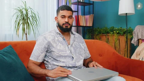 Young man freelancer sitting on couch closing laptop pc after finishing work in Video stock 251670061