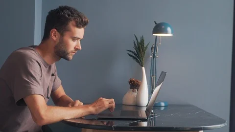 Young Man Freelancer Using Laptop, Typing, Scrolling, Surfing Web Stock Footage 120362126