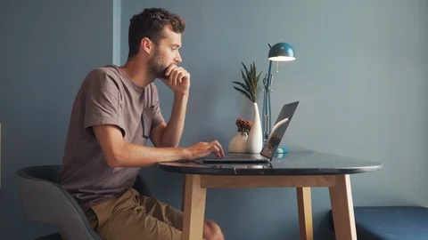 Young Man Freelancer Using Laptop, Typing, Scrolling, Surfing Web Stock Footage 120365036