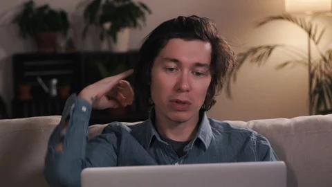 Young man freelancer using laptop studying online working or chatting from home Stock Footage 127394429