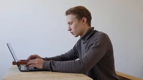 Young man freelancer using laptop and talking on the phone. Professional Stock Footage 129009441