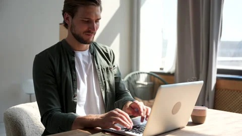 Young man freelancer using laptop online working from home in internet Stock Footage 220868343