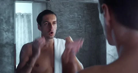Young man in front of mirror speaking to his reflection in mirror to motivate Stock Footage 244069386