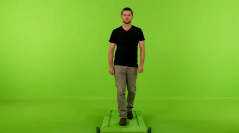 Young man front walking look sides greenscreen 4K Stock Footage 62947485