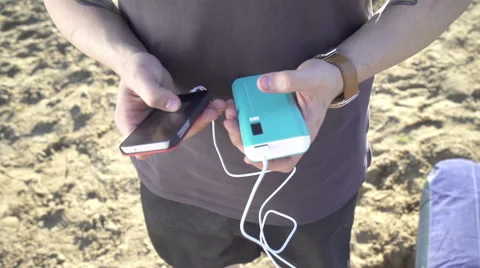 The young man with gadget to charge your smartphone Video stock 65208189