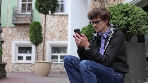 Young Man is Gaining Sms Message on the Phone Stock Footage 64725947
