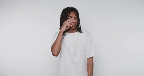 Young man gestures playfully in a bright studio shows the emotion of crying.. Stock Footage 313951160