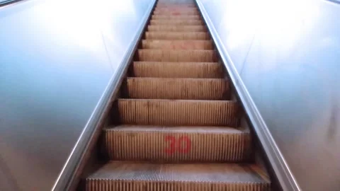 A young man get off the moving up escalator or moving staircase to the exit Stock Footage 171188290