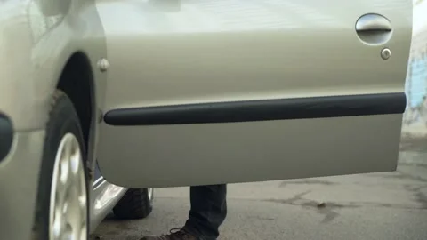 Young man gets into his first used car. Stock Footage 233355322
