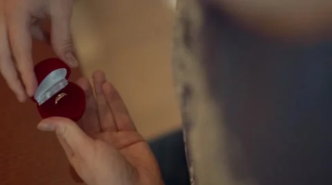 Young man gets out of his pocket a box with a wedding ring and opens it. Video stock 62751963