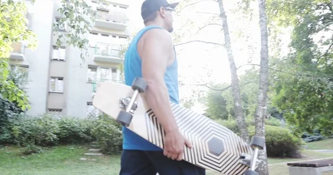 A young man gets on skate and accelerates on the road. Stock Footage 94863756