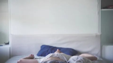 Young man is getting up from the bed at morning Stock Footage 272188367