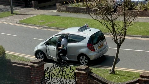 Young man getting into a car for a driving lesson. Stock-Footage 75404764