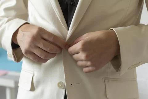 The young man is getting dressed.The concept of fashionable clothing is a clo Stock Photos