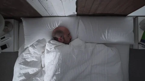 Young man is getting hot in bed at night Видео 71373028