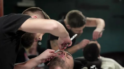 Young man getting an old-fashioned shave with straight razor Stock Footage 252661014