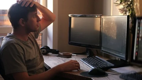 A young man getting ready for work at the computer on the sunset background Stock Footage 71455453