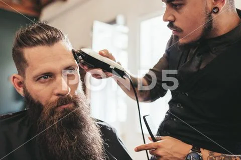 Young man getting trendy haircut at salon Stock Photos