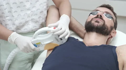 Young man getting underarm laser hair removal epilation. IPL treatment in Video stock 141845157